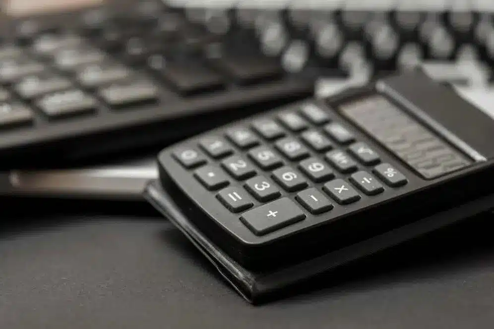 A imagem mostra um teclado numérico de uma calculadora, com os números e símbolos de operações matemáticas básicas, como adição, subtração, multiplicação e divisão. Esse tipo de calculadora é comumente utilizada para realizar cálculos financeiros e contábeis, o que pode ser relevante para o contexto do artigo "PIS / COFINS – Receita esclarece aplicação da suspensão das contribuições".