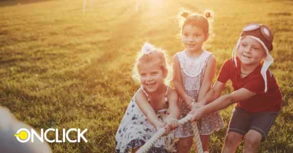 Três crianças sorridentes brincando com uma corda em um campo ao pôr do sol, com o logo da ONCLICK no canto inferior esquerdo. A imagem transmite uma sensação de diversão e momentos felizes da infância.