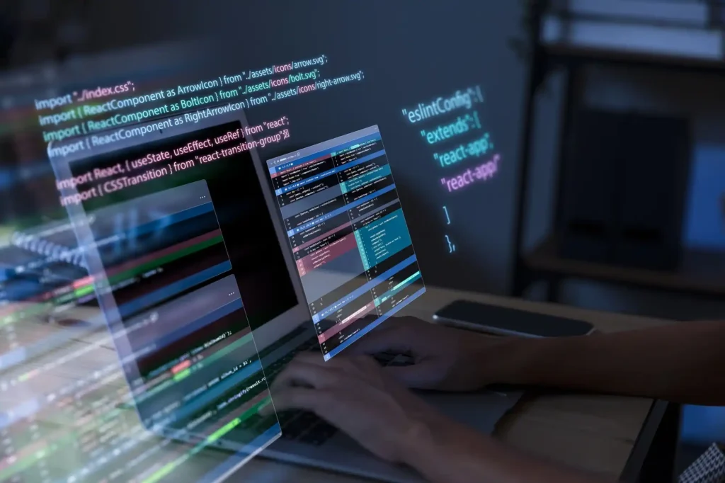 Imagem de uma pessoa programando em um notebook, com hologramas de códigos e interfaces flutuando acima da tela. Representa o desenvolvimento de software, programação e tecnologia de realidade aumentada em ação.