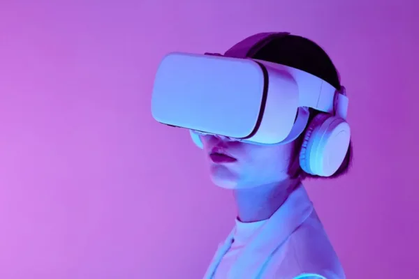 Pessoa usando um dispositivo de realidade virtual (VR) com fones de ouvido, simbolizando a imersão em ambientes virtuais e a experiência de entretenimento digital. Representa a tecnologia de VR e suas aplicações em entretenimento, educação e design.