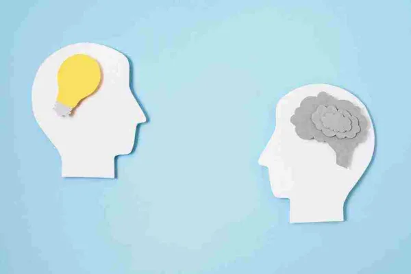 A imagem ilustra dois conceitos de pensamento, com uma silhueta de cabeça com um lâmpada amarela, simbolizando ideias e inovação, e outra com uma nuvem cinza, representando pensamento analítico e crítico. No contexto do artigo sobre mindset digital, isso reflete a importância de desenvolver uma mentalidade aberta a novas tecnologias e práticas digitais, equilibrando a criatividade com a lógica analítica para se adaptar e se destacar no mundo moderno.