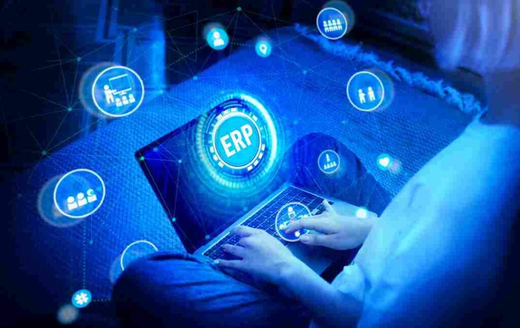A imagem mostra uma mão digitando em um computador com uma interface gráfica futurística e holográfica. O destaque é dado para o logotipo "ERP" (Enterprise Resource Planning), que é uma solução de software empresarial integrada. Essa imagem parece estar relacionada a um artigo sobre os desafios e dicas para trocar de sistema ERP em uma empresa.