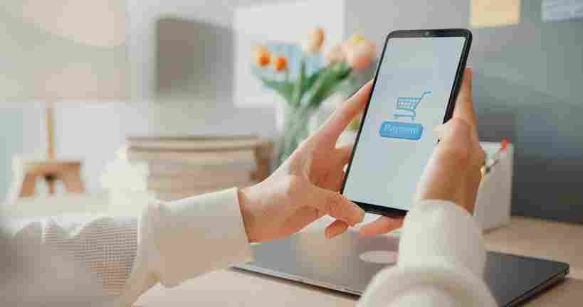 Pessoa utilizando smartphone com carrinho de compras online, representando força de vendas no e-commerce, gestão de loja virtual, experiência do usuário e estratégias de conversão digital.